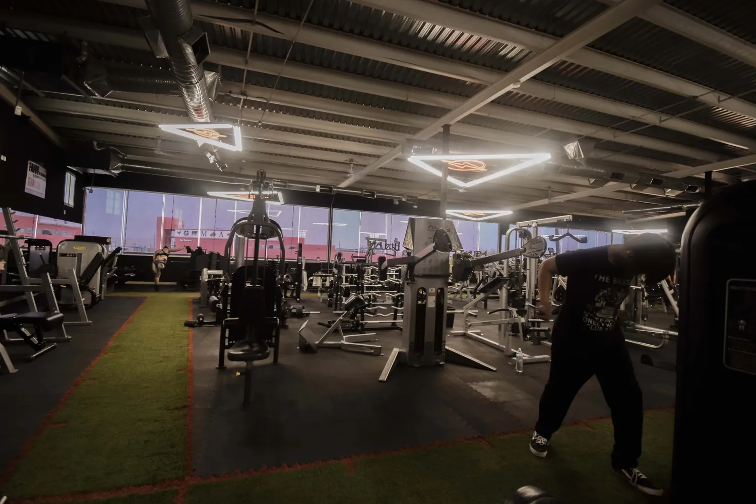 Sala de entrenamiento de Volten Gym Gómez Morín con pasto sintético y ventanales.