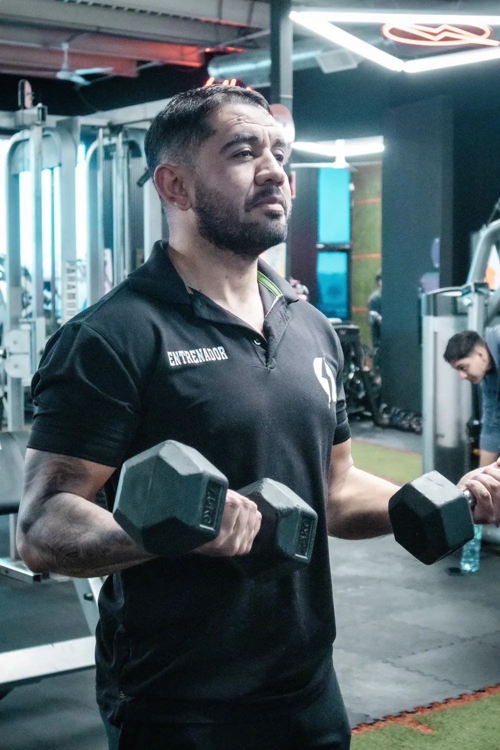 Un entrenador de Volten Gym con mancuernas.