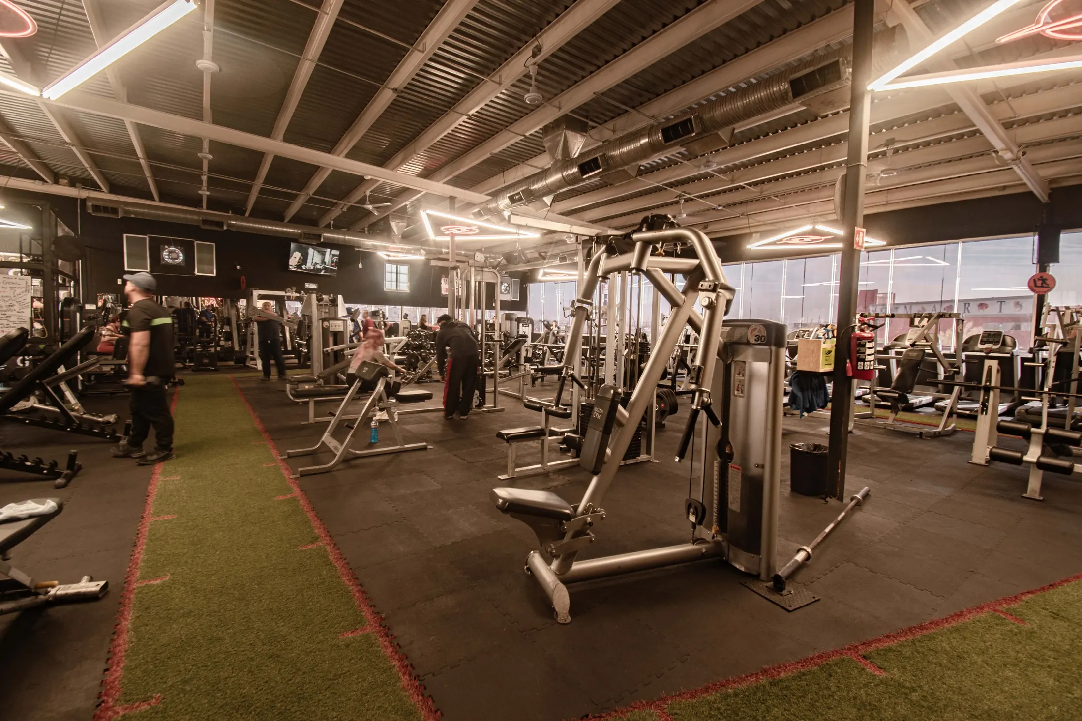 Sala de entrenamiento de Volten Gym Gómez Morín con pasto sintético y letreros luminosos